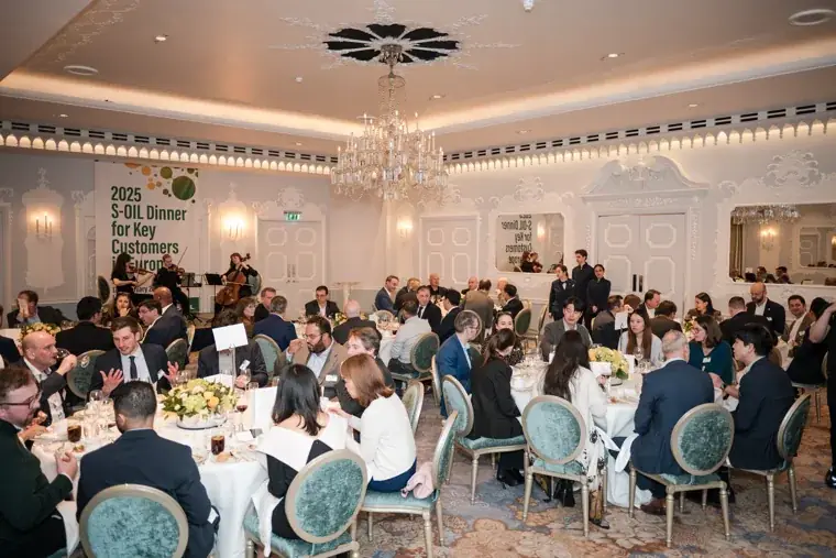 A wide view of the chandelier-lit dinner room at the S-OIL European customer dinner.