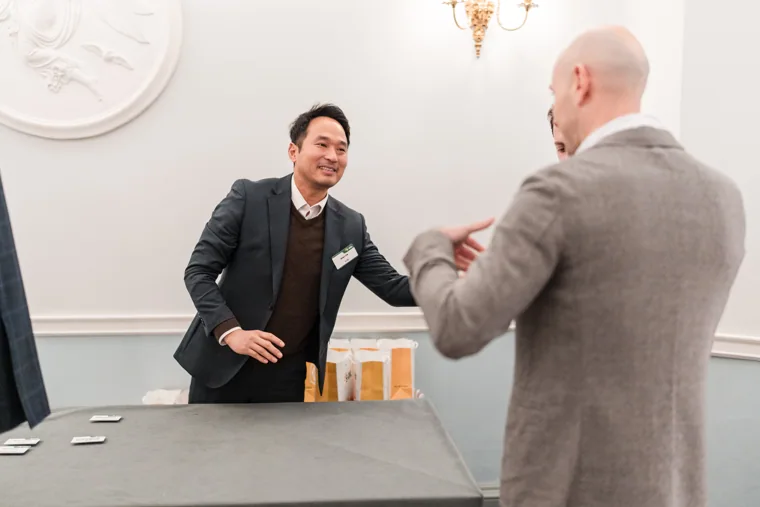 An attendee greeting another guest at the entrance at the S-OIL European customer dinner.