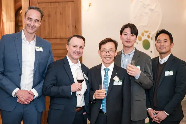 Five guests posing together with drinks at the S-OIL European customer dinner.