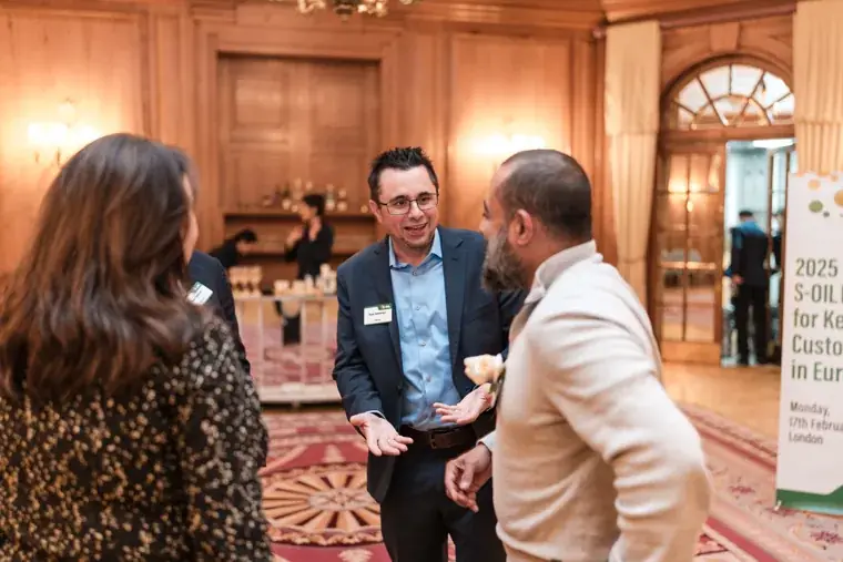 Guests mingling beside the event sign at the S-OIL European customer dinner.