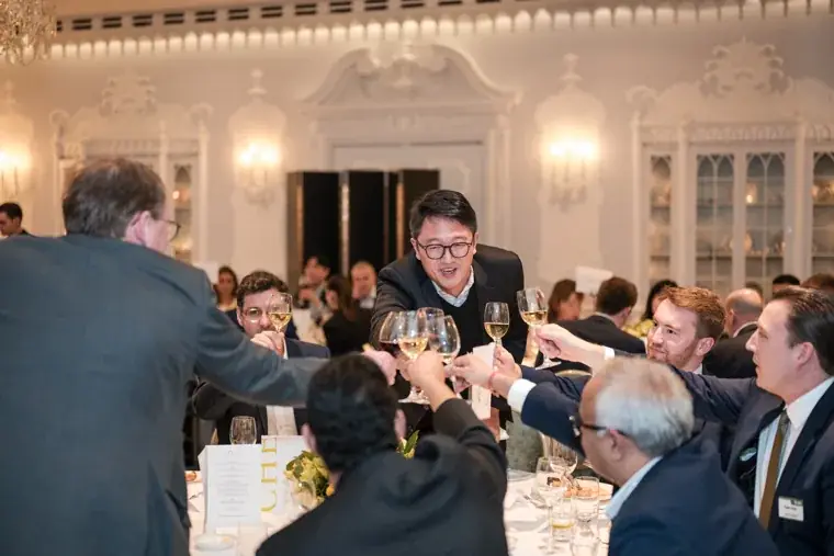 Guests raising glasses across a table at the S-OIL European customer dinner.