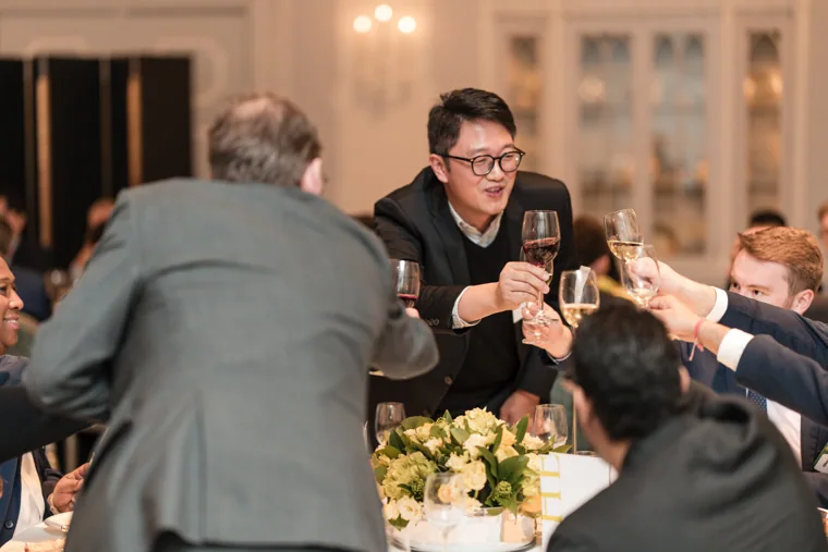 Guests raising glasses together at dinner at the S-OIL European customer dinner.