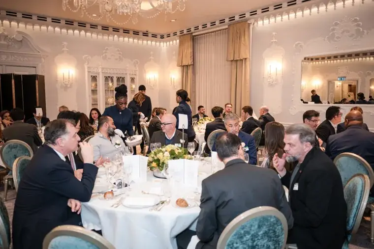 Guests seated around tables in the dining room at the S-OIL European customer dinner.