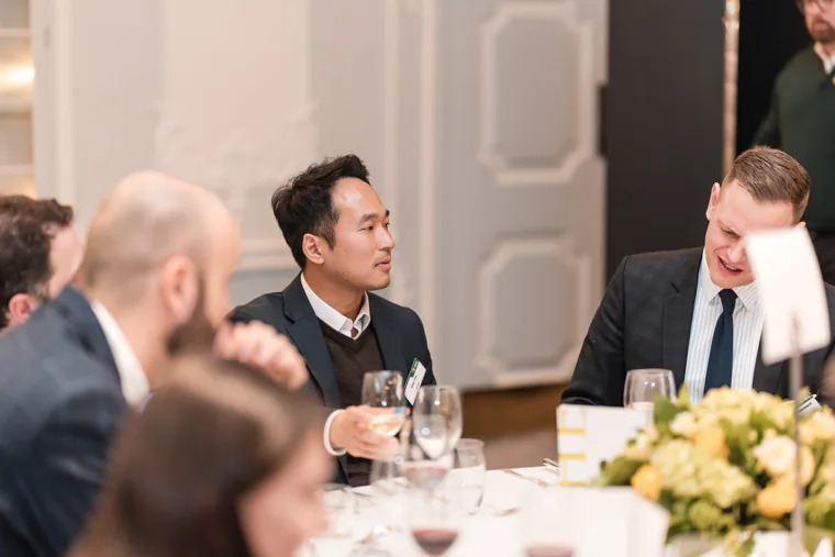 Guests talking across the dinner table at the S-OIL European customer dinner.