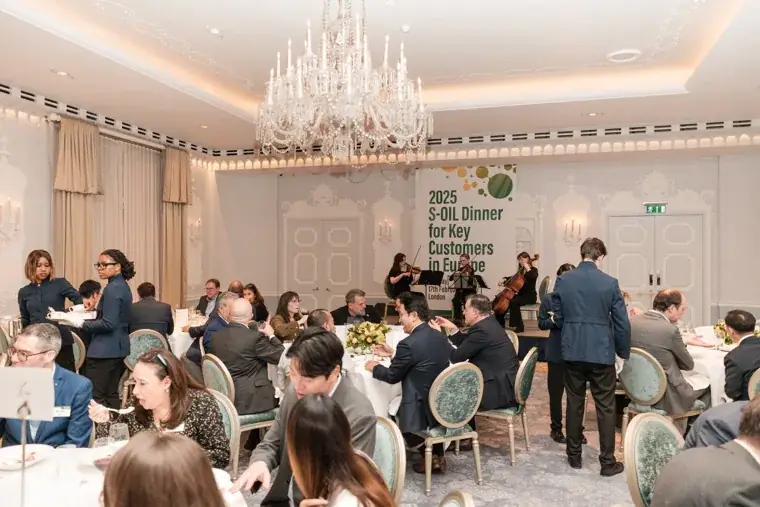 The dining room with guests seated at round tables at the S-OIL European customer dinner.