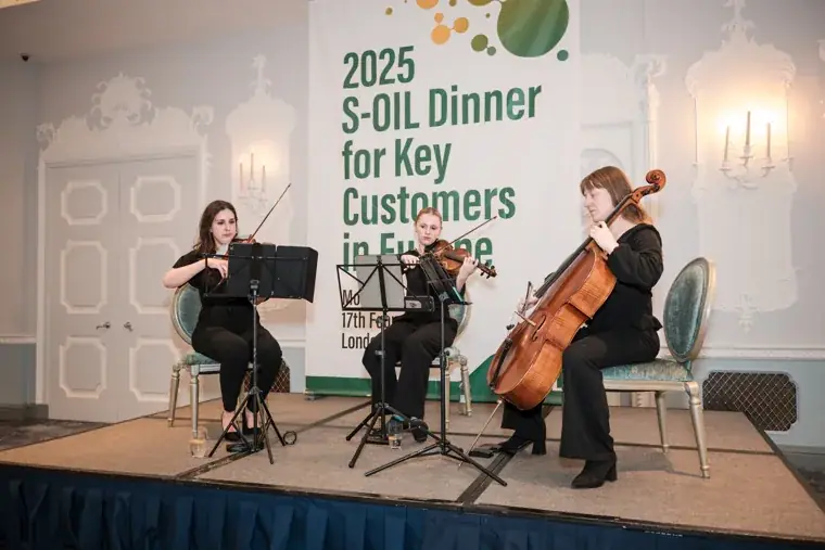 The string trio performing as guests dine at the S-OIL European customer dinner.