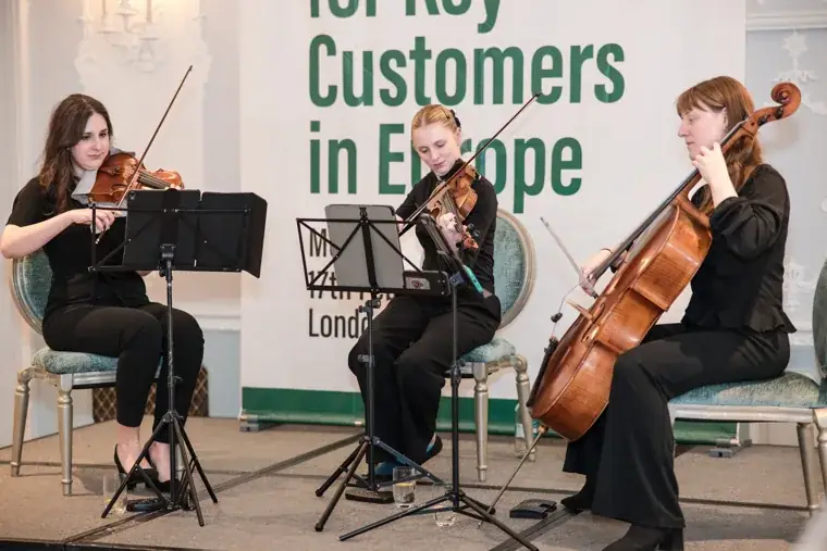 The string trio performing during the meal at the S-OIL European customer dinner.