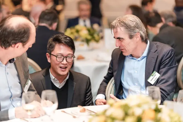 Three guests in conversation over dinner at the S-OIL European customer dinner.