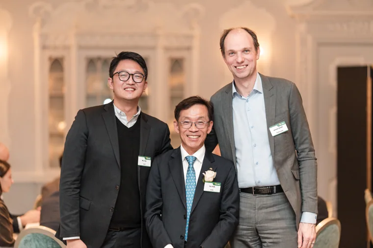 Three guests posing in the reception room at the S-OIL European customer dinner.