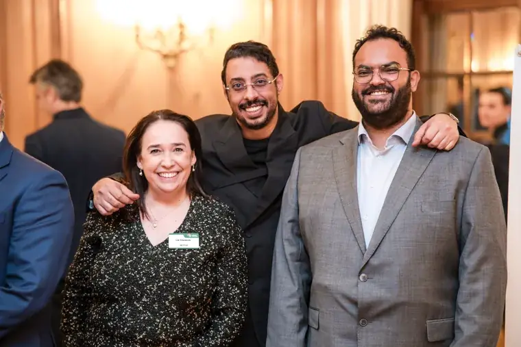 Three guests smiling together at the reception at the S-OIL European customer dinner.