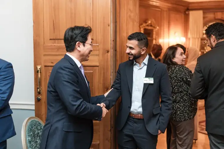 Two guests greeting each other by the doorway at the S-OIL European customer dinner.