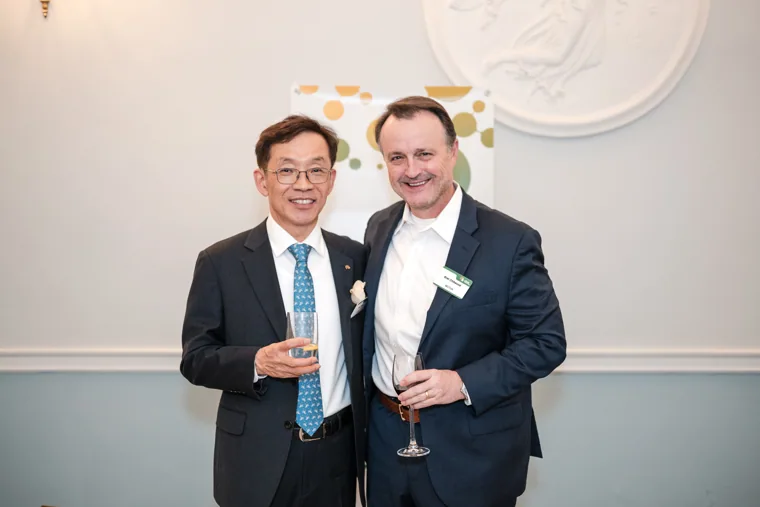 Two guests posing together with drinks at the S-OIL European customer dinner.