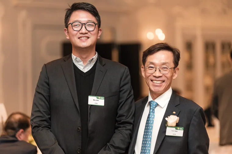Two guests posing with drinks at the S-OIL European customer dinner.