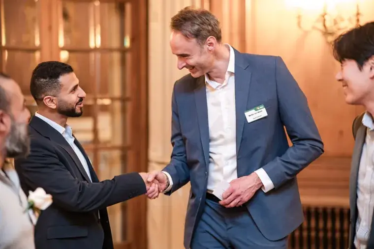 Two guests shaking hands before dinner at the S-OIL European customer dinner.