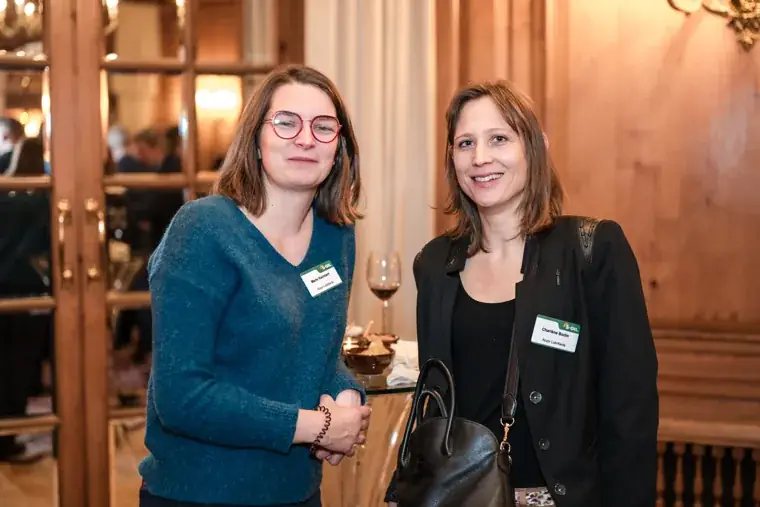 Two women talking in the wood-panelled room at the S-OIL European customer dinner.